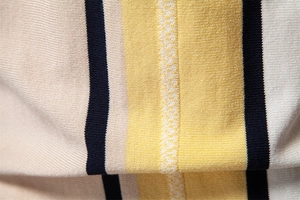 Macro shot of striped knit fabric showing texture and soft drape of the polo shirt