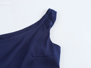 Gros plan d'une robe bleu foncé à une épaule montrant le tissu lisse et la couture