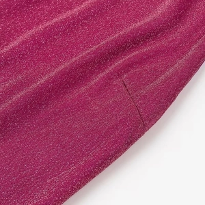 Macro detail of rose red glitter fabric texture and shimmering finish for party dress