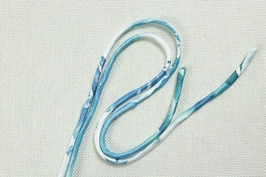 Detailed macro view of blue and white abstract print fabric with fine stitching quality