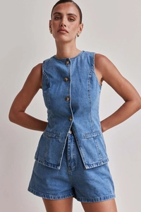 Detaillierte Textur der blauen Denim Weste und Shorts mit Kontrastnähten und Knöpfen