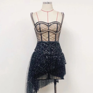 Detail of black sequined dress featuring mesh stitching and elegant spaghetti straps
