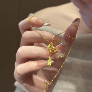 Detailed close-up of 24K gold plated rocking horse pendant with safety charm tag