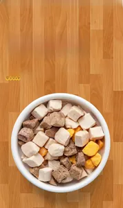 Close-up of mixed flavor pet freeze-dried treats in a white bowl on wooden floor
