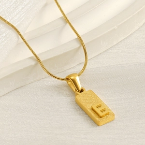 Minimalist gold square pendant necklace with frosted letter E on elegant snake chain