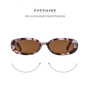 Close-up of vintage oval sunglasses with purple tortoiseshell frames and brown lenses
