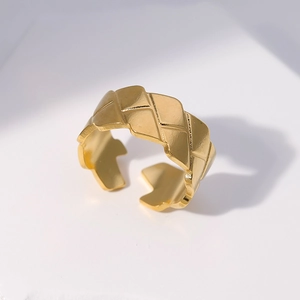 Detailed close-up of a gold-plated adjustable open ring featuring geometric quilted patterns