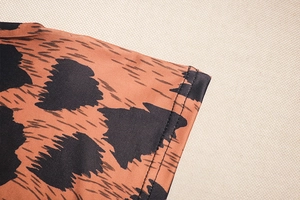 Detail of leopard print knit fabric showing precise double-needle stitching on hem