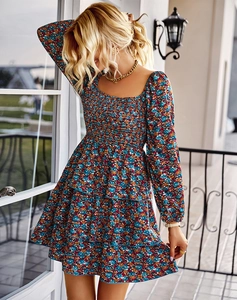 Détail de la robe fleurie bleue avec encolure carrée et jupe à volants étagés