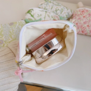 Detailed interior of mini floral cotton storage bag with lipstick and cosmetics