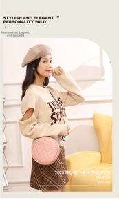 Detailed view of pink quilted round crossbody bag with stylish patterned strap