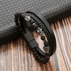 Detail of multi-layer leather bracelet with volcanic stone beads and metal skull charms
