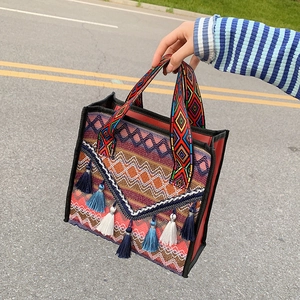 Bohemian woven shoulder bag with colorful geometric patterns and blue fringe tassels