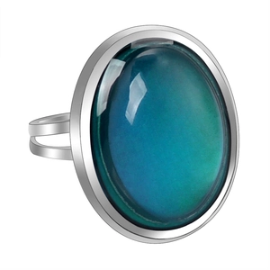 Macro view of adjustable silver ring with oval color-changing blue-green gemstone