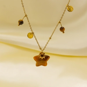 Detail of star-shaped tiger eye stone pendant on a gold chain with polished sequins