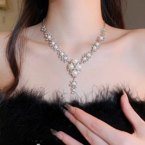 Detailed view of elegant silver necklace with pearls and rhinestones on a model