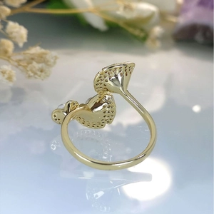 Golden lotus leaf ring with zircon inlay and pearl detail on an elegant background