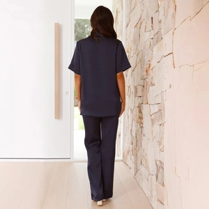 Back view of a woman in navy blue loungewear set with short sleeves and straight pants