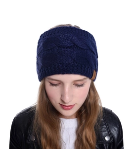 Vue détaillée d'un bandeau d'hiver bleu marine en maille torsadée sur un modèle