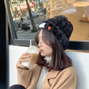 Women's black plush knit beanie with colorful button detail for winter warmth