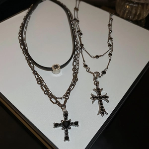 Dettaglio di collane gotiche a strati con croci, strass neri e gemma a forma di cuore
