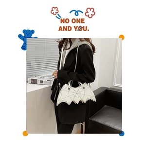 Gothic white bat-shaped PU leather handbag with embroidery and rivet details on a model