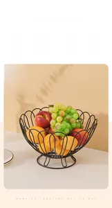 Detail of a black iron fruit basket with a curved petal design holding fresh fruits