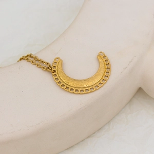 Vue macro du pendentif de collier croissant de lune doré sur mannequin avec cadre chaîne