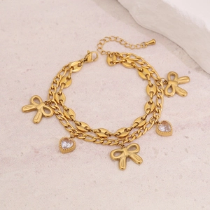 Zweilagiges Armband aus goldenem Titanstahl mit Schleifen-Anhängern und Herz-Zirkonia