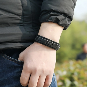 Close-up of black leather multi-layer bracelet with metal rivets on a male wrist