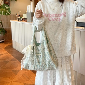 Detail of light green lining and cream lace exterior on a sweet bow shoulder bag