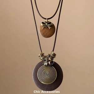 Gros plan des colliers ethniques à double couche avec pendentifs en bois et détails en métal