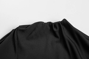 Detail view of the elegant gathered waist and ruched fabric texture of the black dress
