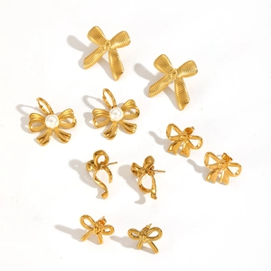 Bow-knot 18k gold plated stainless steel earrings set with pearls on white background
