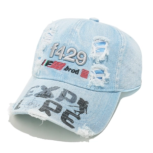 Detail of distressed light blue denim baseball cap with 1429 embroidery and street art print