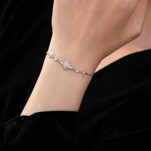 Macro shot of silver star-shaped bracelet with cubic zirconia on a wrist and black velvet