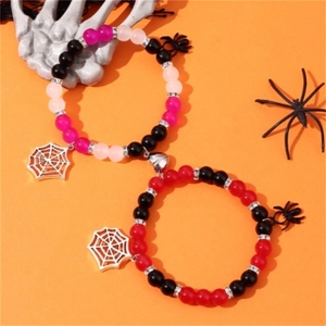 Close-up of magnetic heart couple bracelets with spider charms and Halloween decor