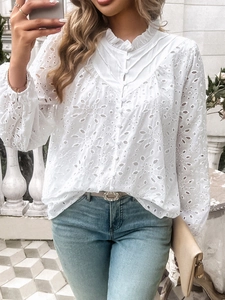 Close-up of white long sleeve top featuring intricate hollow embroidery and button detail