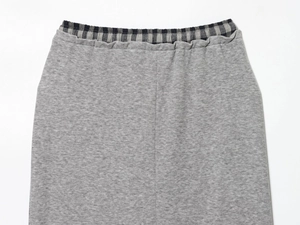 Detail of the elastic waistband on grey knit skirt with black and white plaid lining