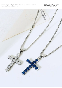 Detailed shot of titanium steel cross necklaces with blue and clear zircon crystals