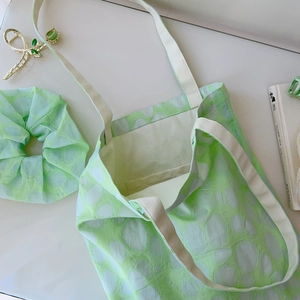 Detail of light green bubble texture tote bag with matching scrunchie and leaf clip