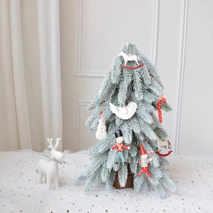 Miniature flocked white snow Christmas tree with red and blue nutcracker ornaments