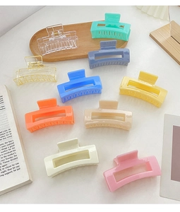 Collection of matte macaron square hair claws on a desk with a book for a cozy aesthetic