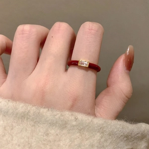 Elegant gold open ring with red enamel and rectangular zircon worn on a hand