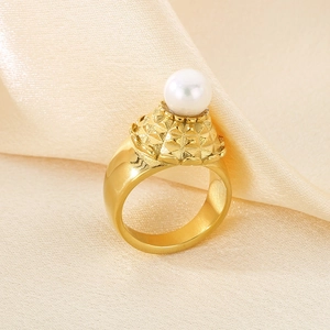 Vista dettagliata dell'anello con perla dorata su un elegante tessuto di seta beige