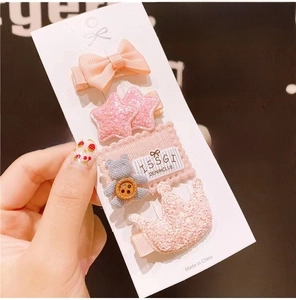 Detailed close-up of pink children's hair clip set with bow, star, and bear designs