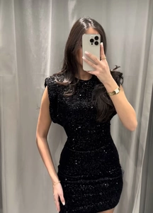 Gros plan d'une robe courte noire à paillettes sans manches sur un mannequin ajusté