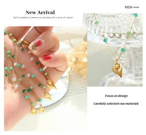 Detail of tulip pendant gold chain with green and white crystal beads on glassware