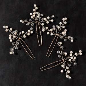Macro view of 4-piece handmade bridal hair pins with gold wire, pearls and crystals