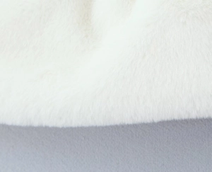Gros plan détaillé de la texture douce en fausse fourrure blanche du châle